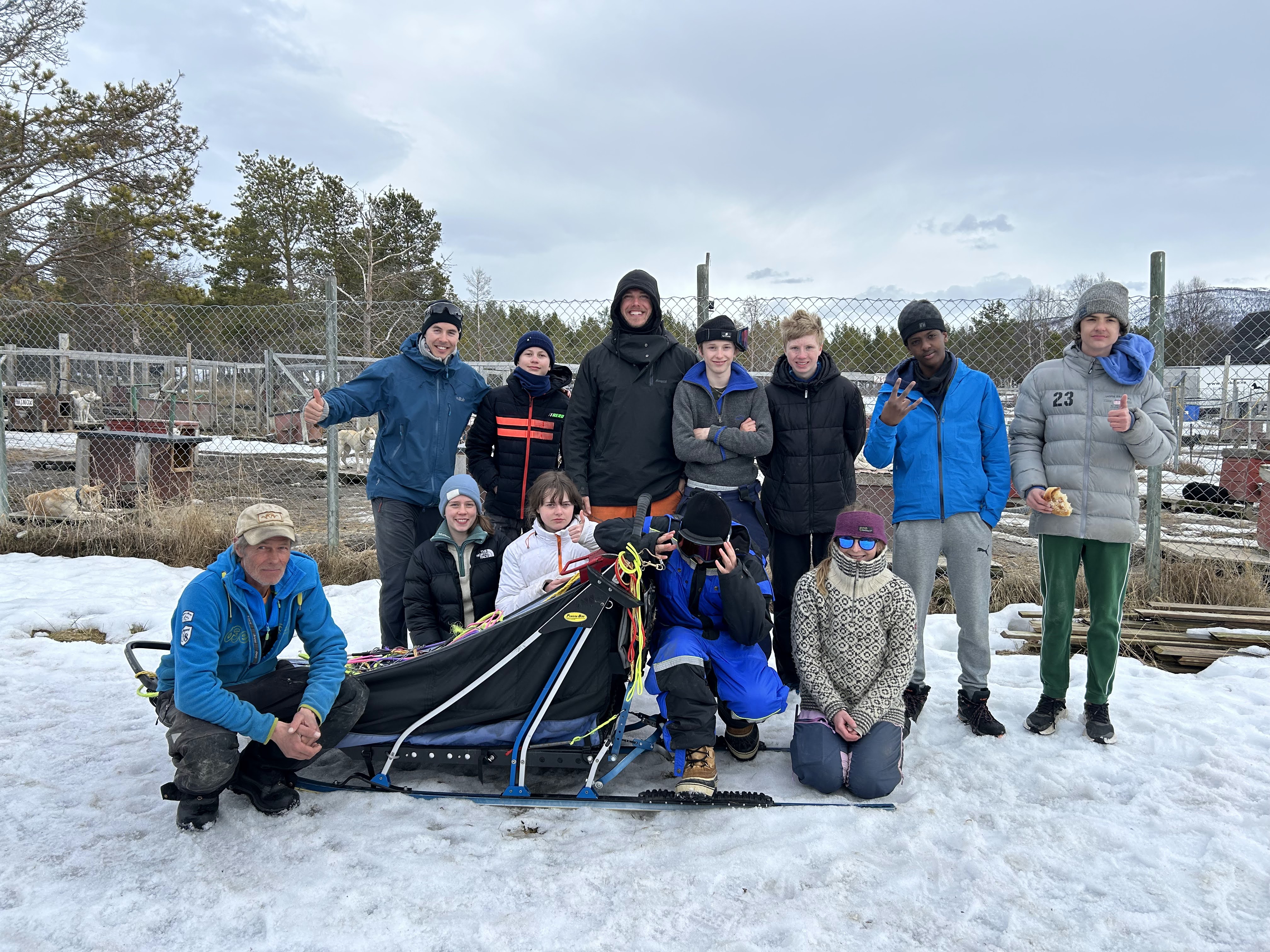 en gruppe mennesker som poserer for et bilde med en slede
