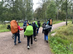 En gruppe mennesker som går på en sti i skogen
