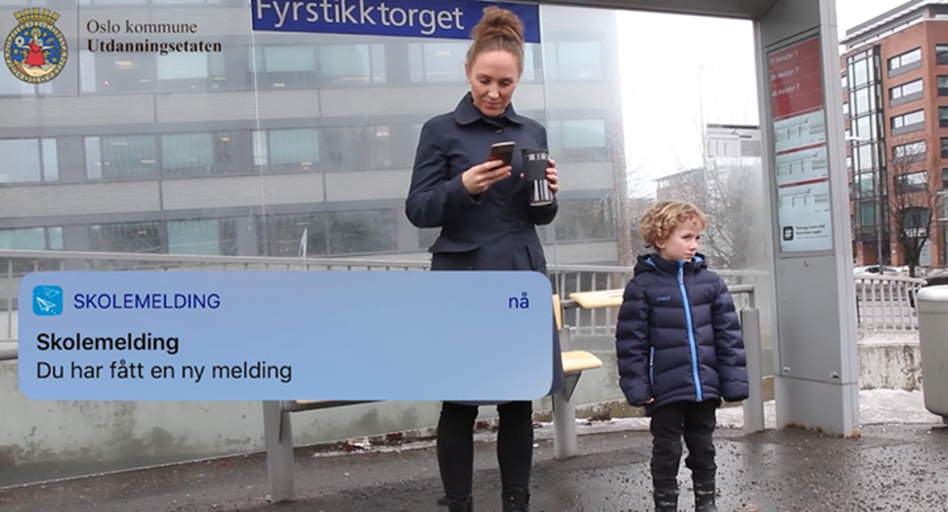 en person og et barn som tar et bilde foran en bygning